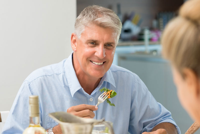 older patient with new implant supported dentures enjoying function of teeth