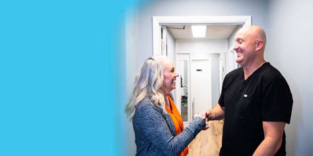 Dr. R. Benjamin Scott shaking patients hand after he helped patient with dental implants